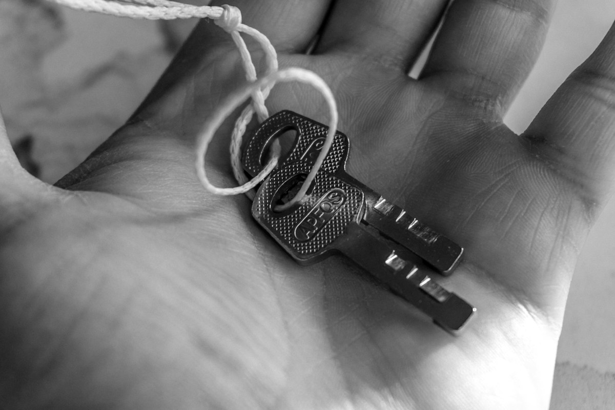 Two keys tied together resting in a palm